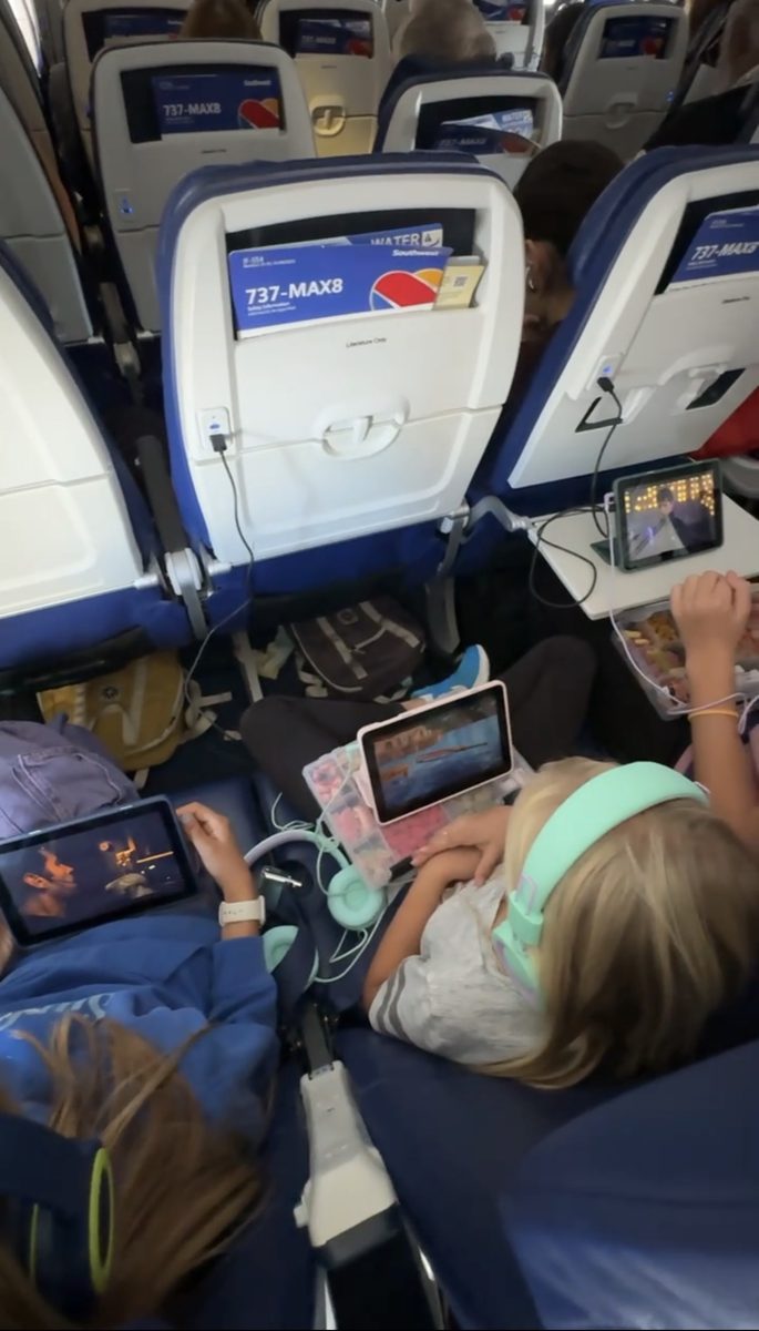 Kids watching shows on travel tablets during a flight