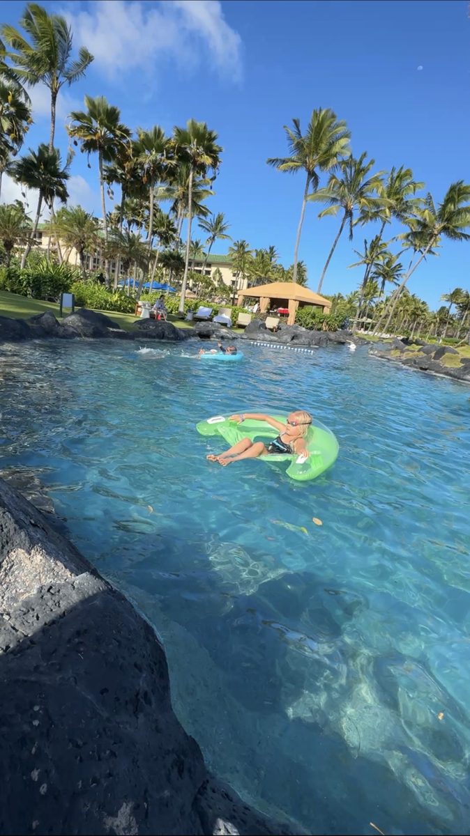 Child relaxing on a pool float in a resort lazy river in Kauai